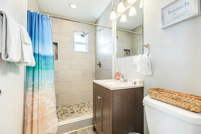4006 Reeves Dr, Galveston, TX 77554 - full bathroom with vanity, toilet, a tile shower, and wood finished floors