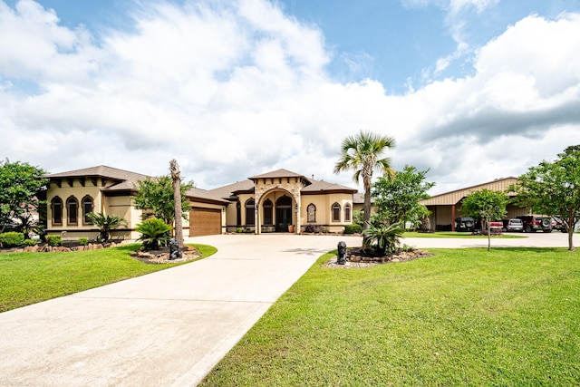 mediterranean / spanish house with a garage, a front lawn, stucco siding, and concrete driveway