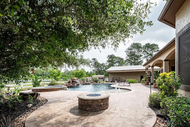 view of swimming pool featuring a patio, an outdoor fire pit, and a pool with connected hot tub