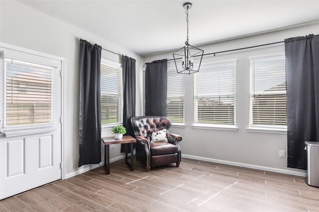 sitting room featuring a chandelier, baseboards, and wood finished floors