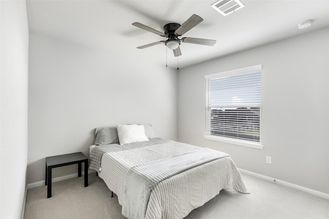 carpeted bedroom with visible vents, a ceiling fan, and baseboards