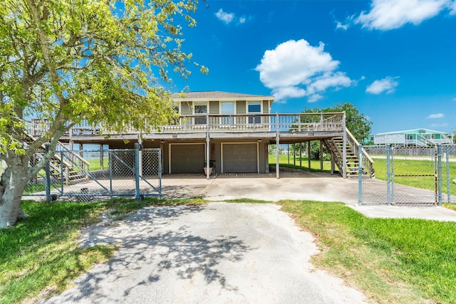 1102 15th St, San Leon, TX 77539 - view of front of property with concrete driveway, a wooden deck, an attached garage, fence, and stairway