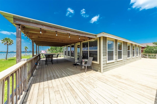 1102 15th St, San Leon, TX 77539 - wooden deck with outdoor dining area and a water view