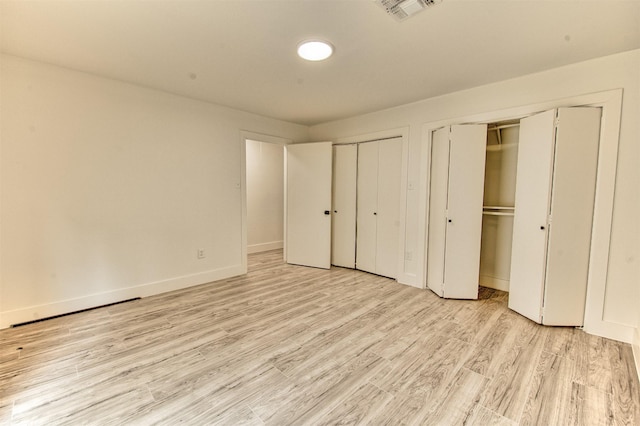 15626 Whitewater Ln, Houston, TX 77079 - unfurnished bedroom featuring multiple closets, baseboards, light wood-type flooring, and visible vents