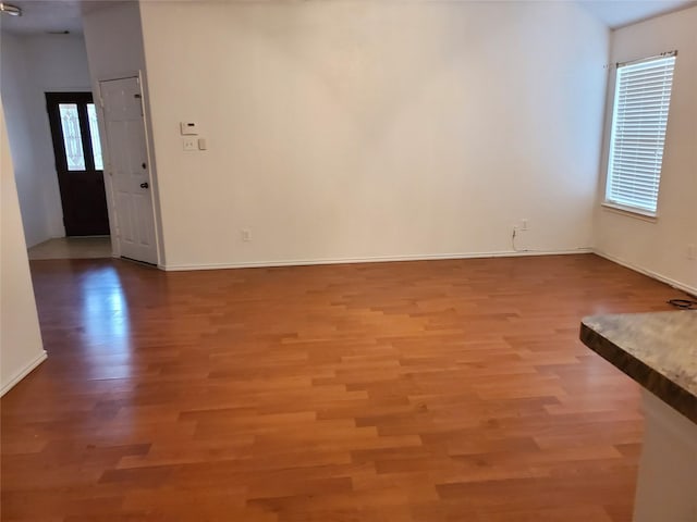 empty room with baseboards and light wood finished floors
