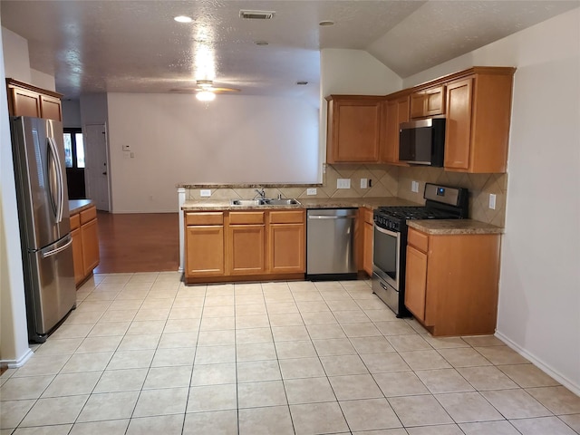 kitchen with a sink, appliances with stainless steel finishes, visible vents, ceiling fan, and a peninsula