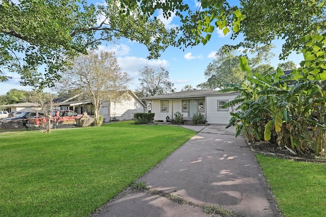 single story home with a front lawn, driveway, and fence