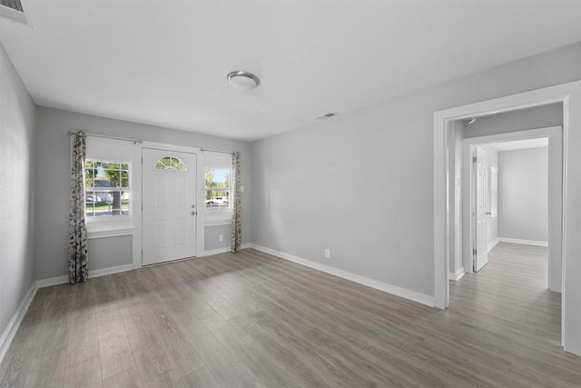 foyer entrance with visible vents, wood finished floors, and baseboards