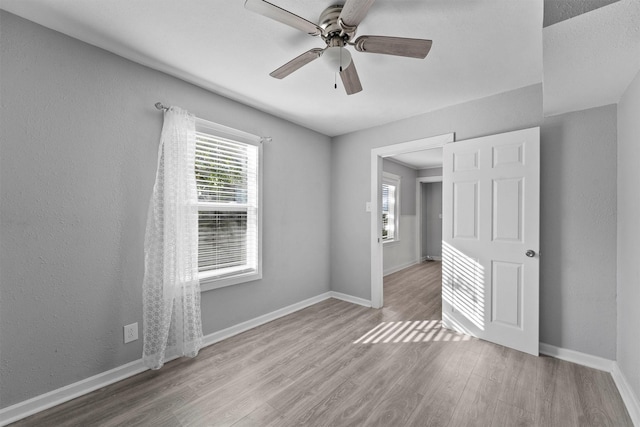 interior space with ceiling fan, wood finished floors, and baseboards