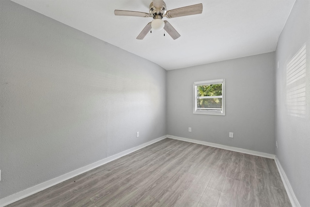 spare room with wood finished floors, ceiling fan, and baseboards
