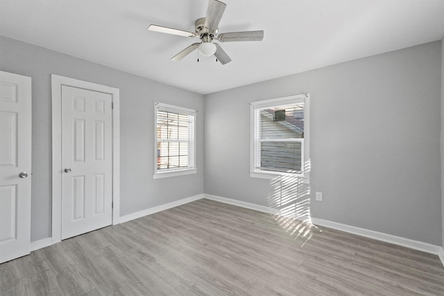 unfurnished bedroom with baseboards, ceiling fan, and light wood-style floors