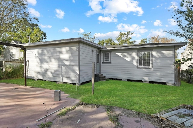 back of house with a lawn and entry steps
