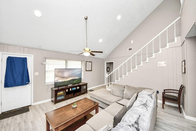 living area featuring stairway, light wood-style floors, ceiling fan, and visible vents