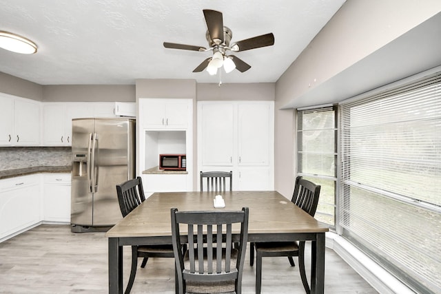 dining area featuring ceiling fan and light wood finished floors