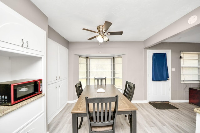 dining area with baseboards, light wood-type flooring, ceiling fan, and a healthy amount of sunlight