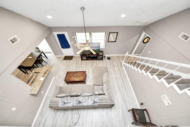 living area featuring recessed lighting, visible vents, and wood finished floors