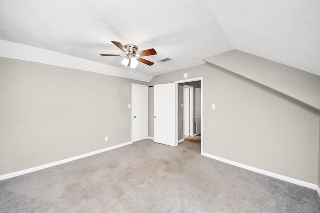 additional living space with carpet, vaulted ceiling, baseboards, visible vents, and a ceiling fan