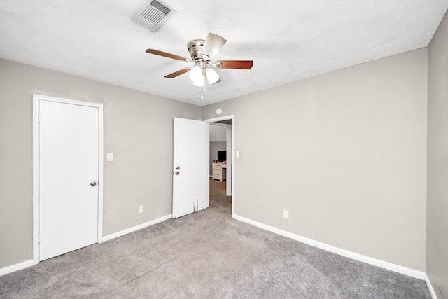 unfurnished bedroom with a ceiling fan, visible vents, carpet, and baseboards