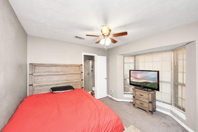 carpeted bedroom featuring baseboards, visible vents, ceiling fan, and ensuite bathroom