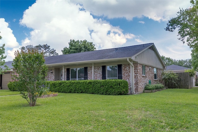 exterior space featuring fence, a front yard, and brick siding