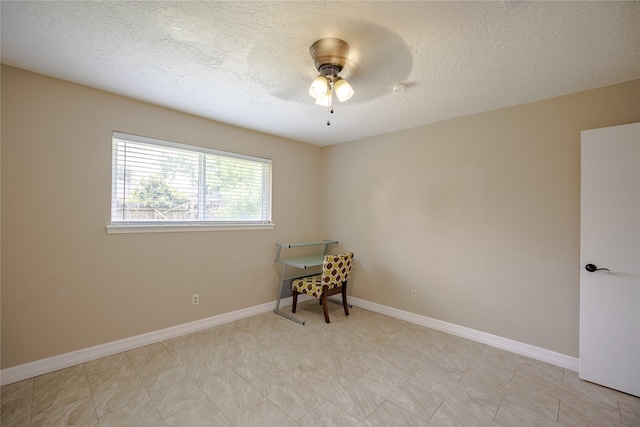 unfurnished room featuring a ceiling fan, a textured ceiling, and baseboards