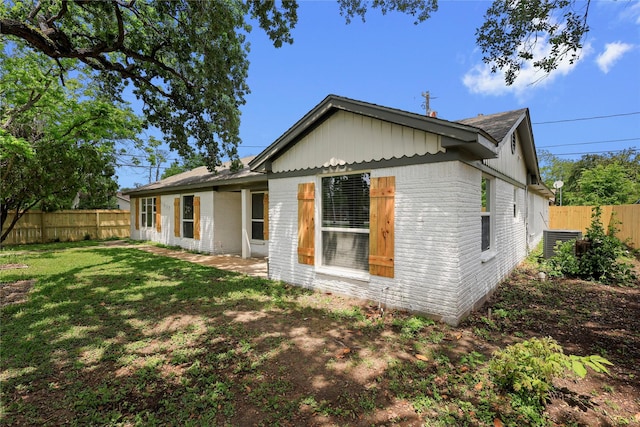 view of home's exterior featuring a lawn, a fenced backyard, and brick siding