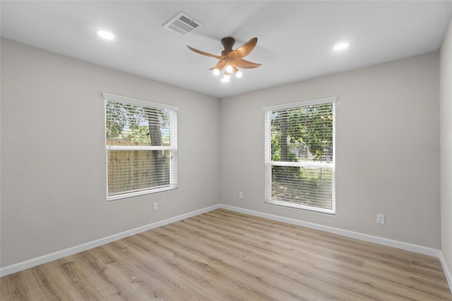 empty room featuring light wood-type flooring, visible vents, and a healthy amount of sunlight