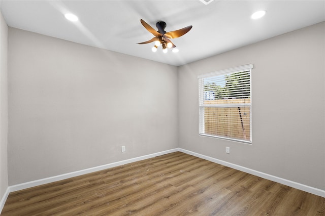 spare room with recessed lighting, a ceiling fan, wood finished floors, and baseboards