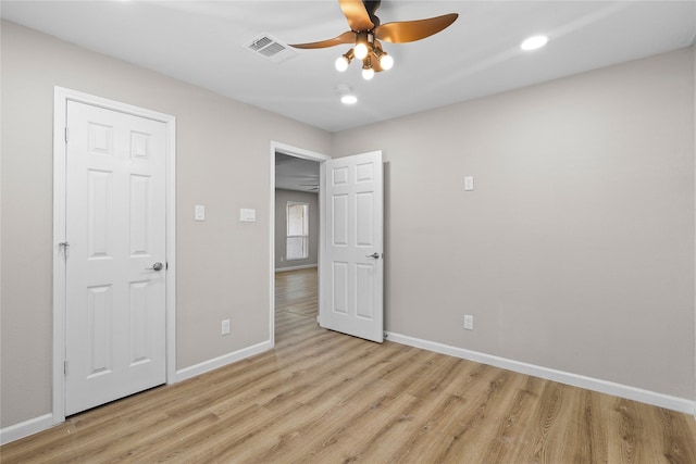 unfurnished bedroom with visible vents, light wood-type flooring, a ceiling fan, and baseboards