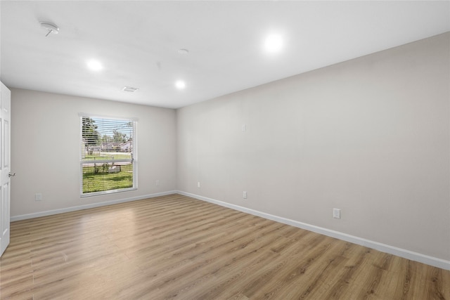 unfurnished room featuring recessed lighting, light wood-style flooring, and baseboards