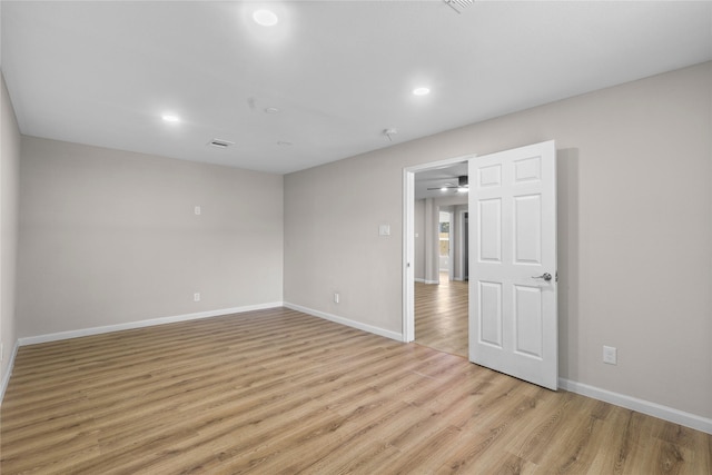 unfurnished room featuring baseboards, light wood-type flooring, and recessed lighting