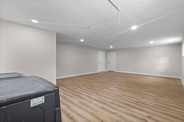 below grade area with recessed lighting, visible vents, and light wood-type flooring