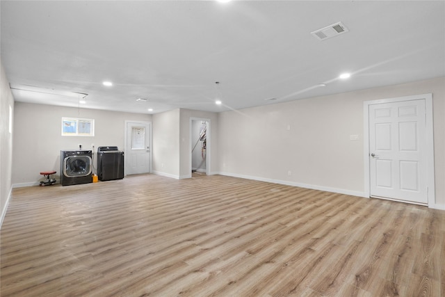 below grade area with recessed lighting, washing machine and clothes dryer, light wood-style flooring, and baseboards