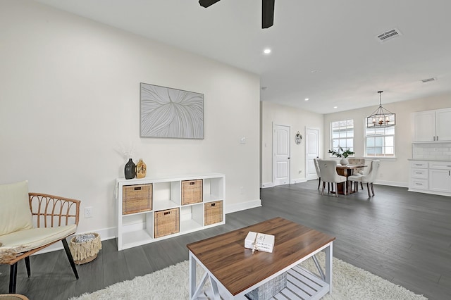 living area featuring recessed lighting, ceiling fan with notable chandelier, dark wood-style floors, and visible vents