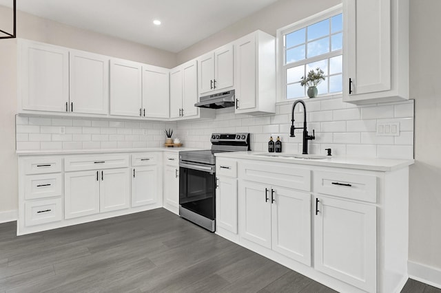 kitchen featuring a sink, light countertops, electric stove, under cabinet range hood, and white cabinetry