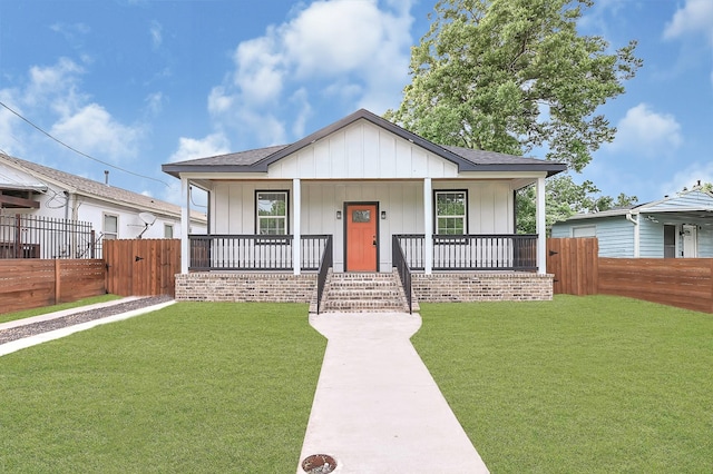 bungalow with a porch, fence, a gate, and a front yard