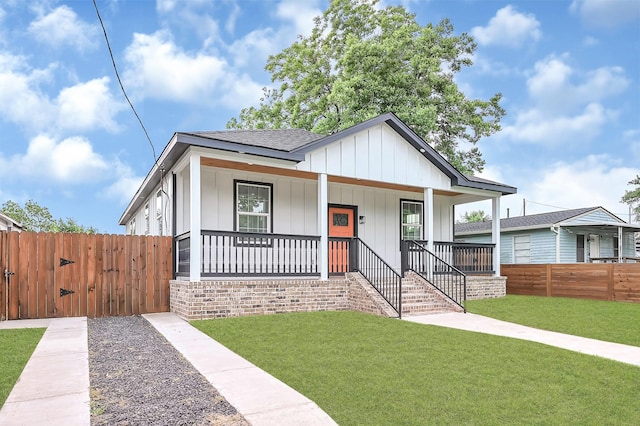 bungalow-style home featuring a porch, fence, a gate, and a front yard