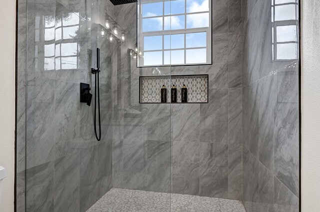full bathroom with plenty of natural light and tiled shower