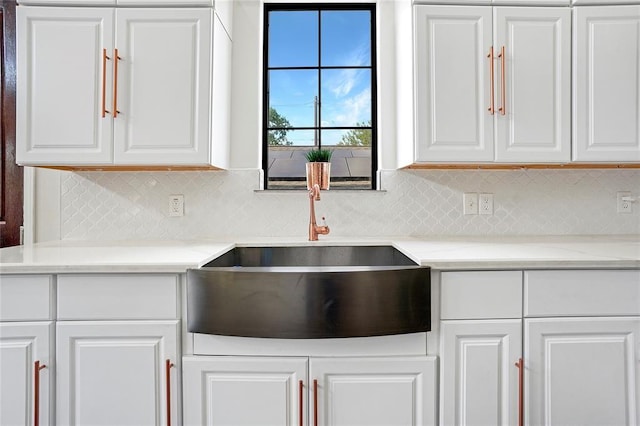 11215 Duane St, Houston, TX 77047 - kitchen featuring white cabinets, backsplash, light stone countertops, and a sink