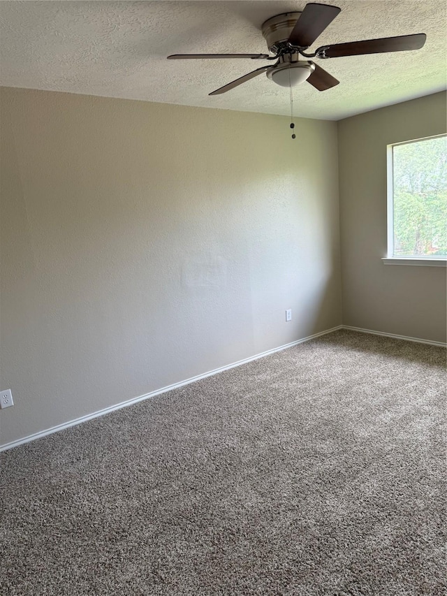 carpeted spare room with baseboards, a ceiling fan, and a textured ceiling