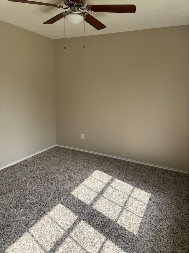 carpeted spare room with baseboards and ceiling fan