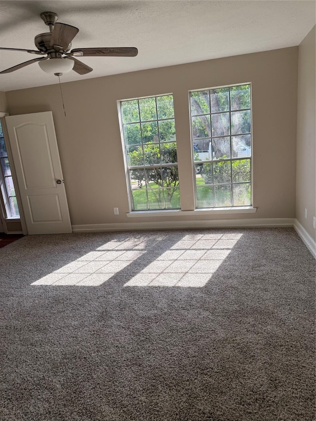 unfurnished room featuring a ceiling fan, carpet flooring, and baseboards