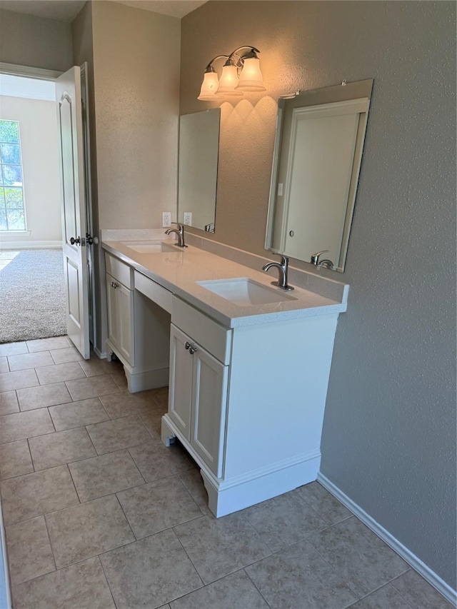 bathroom featuring a textured wall, tile patterned flooring, double vanity, and a sink