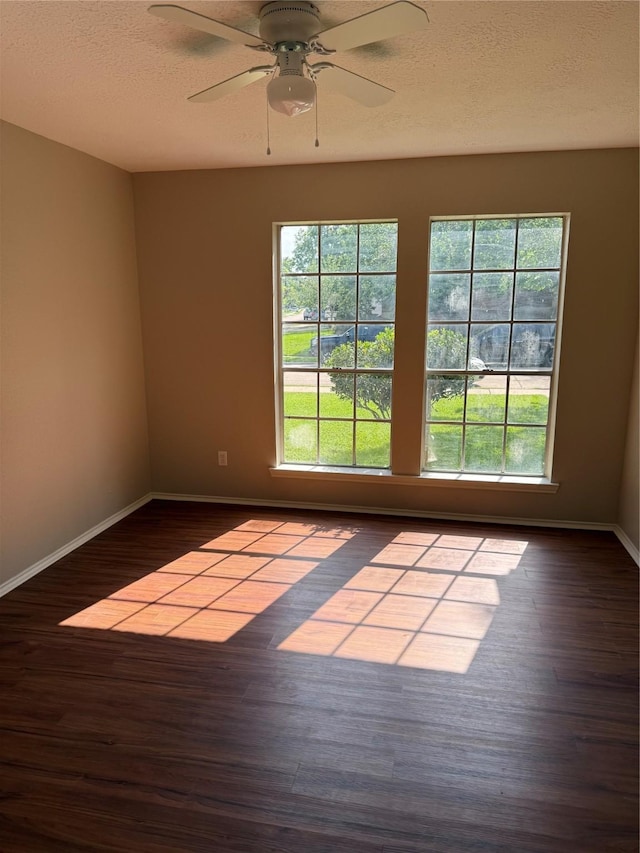 unfurnished room featuring baseboards, wood finished floors, and a ceiling fan