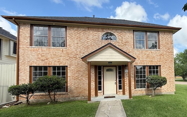 view of front of property with a front yard and brick siding