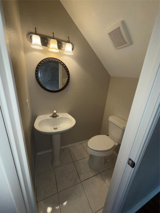 half bathroom featuring baseboards, visible vents, toilet, and lofted ceiling