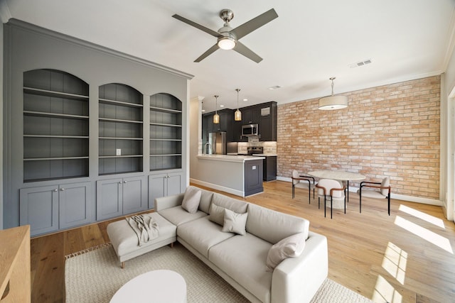 3708 Lake St, Houston, TX 77098 - living area with crown molding, visible vents, ceiling fan, brick wall, and light wood finished floors