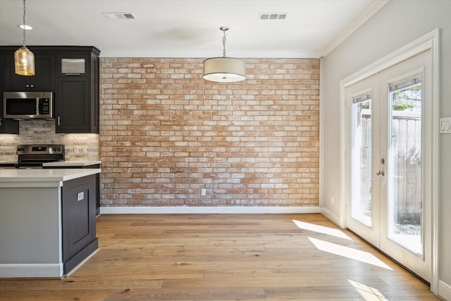 3708 Lake St, Houston, TX 77098 - kitchen featuring decorative light fixtures, appliances with stainless steel finishes, brick wall, and light countertops