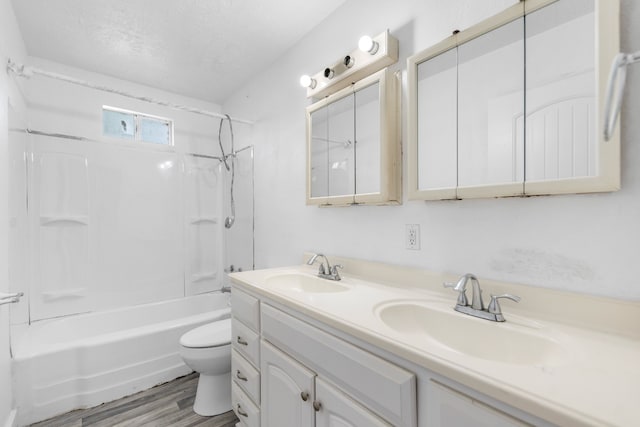 bathroom with bathing tub / shower combination, toilet, double vanity, and a sink