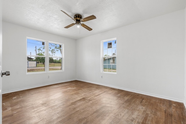 unfurnished room featuring a ceiling fan, wood finished floors, and baseboards